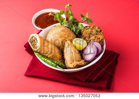 coriander vada or kothimbir vada, samosa, kachori, daal vada on brown wooden planks. indian assorted snacks. Indian snacks combination. Indian snacks group, indian favourite snacks, asian spicy snacks