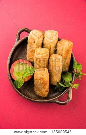 veg roll in brown ceramic bowl with mint leaf