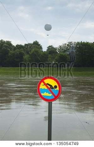 Poland Kraków flooded Vistula/Wisła river embankments no swimming sign over the water sightseeing baloon in the background
