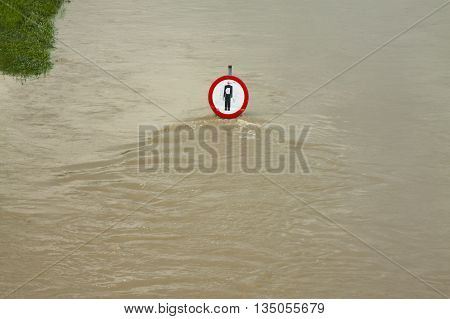 No entry sign on a flooded river embankment