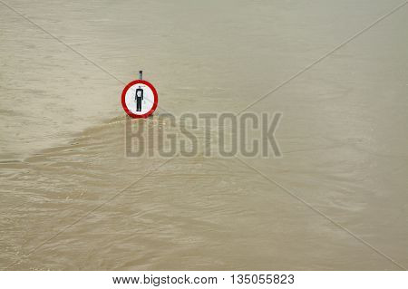 No entry sign on a flooded river embankment