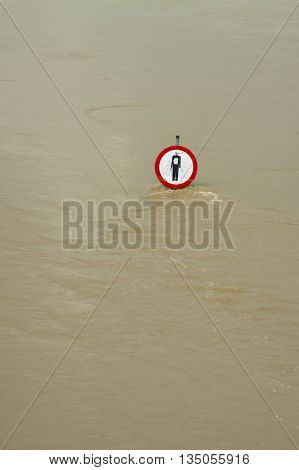 No entry sign on a flooded river embankment