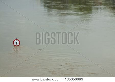 No entry sign on a flooded river embankment