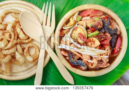 santol salad with pork rind in wooden bowl top view