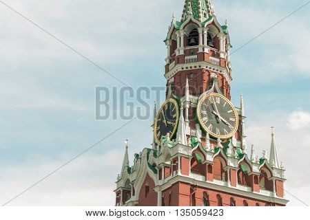 Kremlin tower of red brick, with a big clock on a sky background