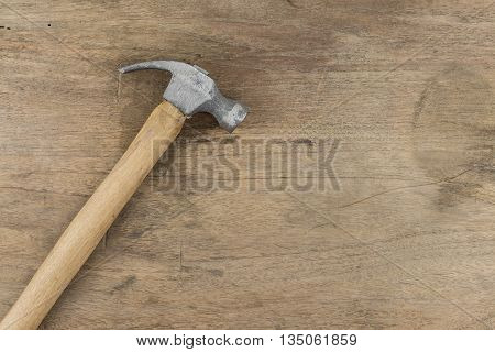 Small Hammer on wood background, wooden panel