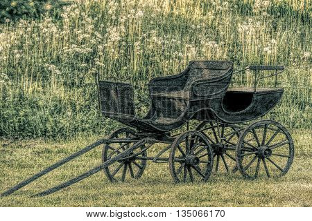 Old black and worn stage coach  in old  vintage photo style.