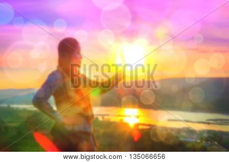Abstract Blurred and soft photo of Women on hilltop with bokeh of sunrise on the natural background