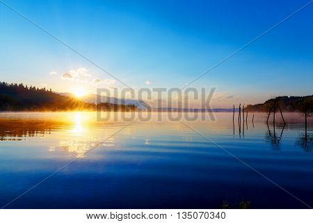 Beautiful Lake View In Morning Fog With Mystic Mountains And Tre