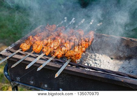 Juicy slices of meat with sauce prepare on fire.