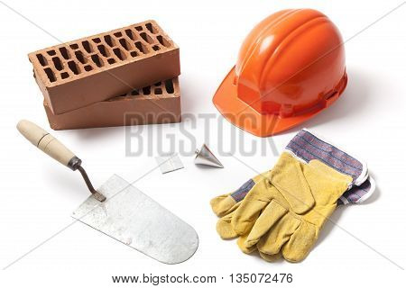 Several construction accessories trowel bricks plummet hard hat and gloves isolated on white background.