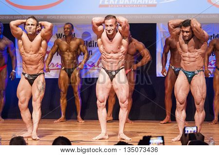 MAASTRICHT THE NETHERLANDS - OCTOBER 25 2015: Male bodybuilders flex their muscles and shows their best abdominal and thighs pose on stage at the World Grandprix Bodybuilding and Fitness of the WBBF-WFF