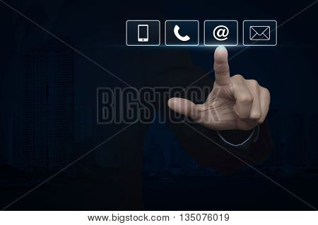 Businessman pressing telephone mobile phone at and email buttons over city tower Customer support concept
