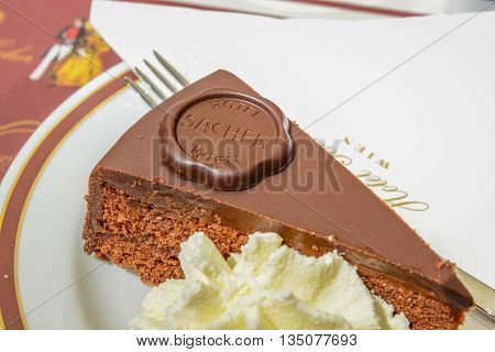 VIENNA AUSTRIA - JUNE 01. 2016: Original Sacher Torte with cream and fork at Sacher Cafe Vienna Austria Europe june 01 2016