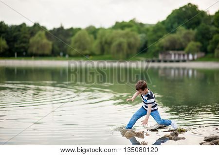 little boy lost his balance and went into the lake
