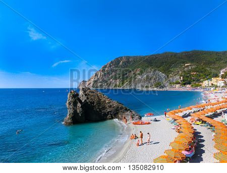 MONTEROSSO, ITALY - SEPTEMBER 09, 2015: People on the coastline of Monterosso in Italy. Monterosso is one of five famous coastline villages in the Cinque Terre National Park.
