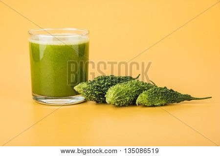 Herbal juice of green momodica in a glass with sliced vegetables, karela juice or bitter gourd juice