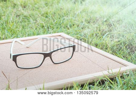 Closeup glasses on cork board textured background