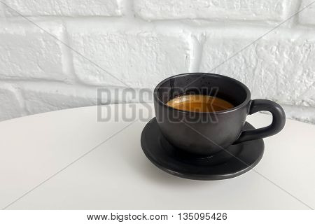 Black coffee in Black cup on white table.