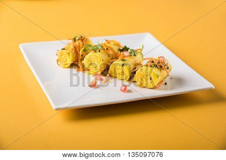 khandvi is a gujarati snack from India which is made with gram flour and curds tempered with sesame seeds and mustard seeds also known as Surali chya Vadya/Stuffed Khandvi, selective focus