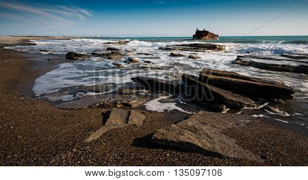 Shipwreck of an abandoned ship on a rocky coast at Akrotiri Beach in Cyprus