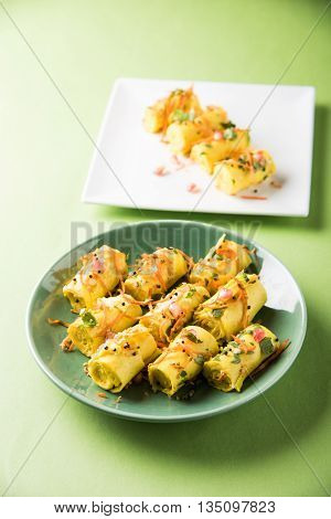 khandvi is a gujarati snack from India which is made with gram flour and curds tempered with sesame seeds and mustard seeds also known as Surali chya Vadya/Stuffed Khandvi, selective focus