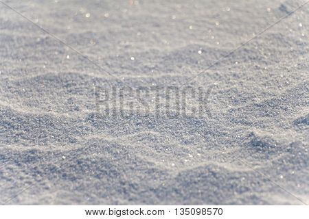 Snow grains close up. Blurred in the distance. Snow cover is not smooth.