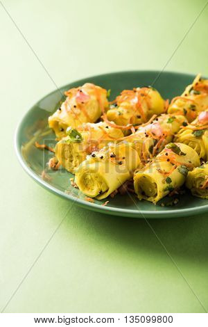 khandvi is a gujarati snack from India which is made with gram flour and curds tempered with sesame seeds and mustard seeds also known as Surali chya Vadya/Stuffed Khandvi, selective focus