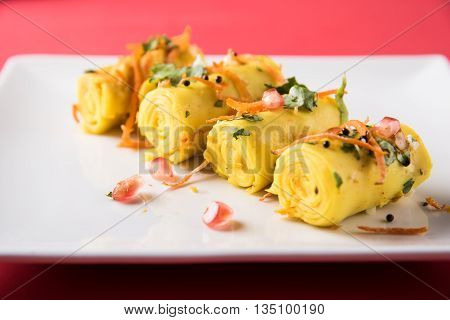 khandvi is a gujarati snack from India which is made with gram flour and curds tempered with sesame seeds and mustard seeds also known as Surali chya Vadya/Stuffed Khandvi, selective focus