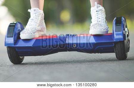 Woman feet  on the hover board. Modern  electric mini hover board gyroscooter outdoor. Mini Segway.