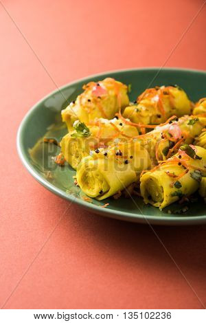 khandvi is a gujarati snack from India which is made with gram flour and curds tempered with sesame seeds and mustard seeds also known as Surali chya Vadya/Stuffed Khandvi, selective focus