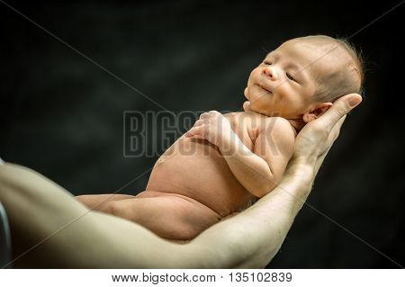 Infant Resting On His Father's Hand