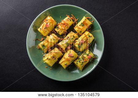 khandvi is a gujarati snack from India which is made with gram flour and curds tempered with sesame seeds and mustard seeds also known as Surali chya Vadya/Stuffed Khandvi, selective focus