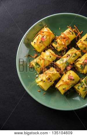 khandvi is a gujarati snack from India which is made with gram flour and curds tempered with sesame seeds and mustard seeds also known as Surali chya Vadya/Stuffed Khandvi, selective focus