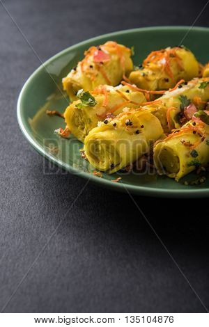 khandvi is a gujarati snack from India which is made with gram flour and curds tempered with sesame seeds and mustard seeds also known as Surali chya Vadya/Stuffed Khandvi, selective focus