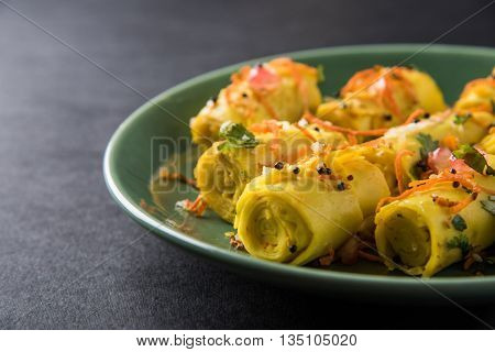 khandvi is a gujarati snack from India which is made with gram flour and curds tempered with sesame seeds and mustard seeds also known as Surali chya Vadya/Stuffed Khandvi, selective focus