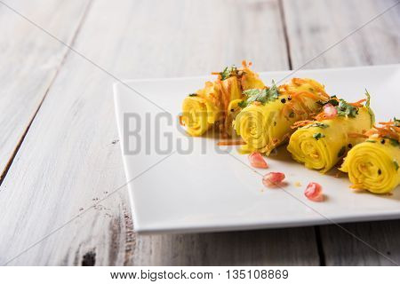 khandvi is a gujarati snack from India which is made with gram flour and curds tempered with sesame seeds and mustard seeds also known as Surali chya Vadya/Stuffed Khandvi, selective focus