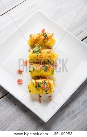 khandvi is a gujarati snack from India which is made with gram flour and curds tempered with sesame seeds and mustard seeds also known as Surali chya Vadya/Stuffed Khandvi, selective focus