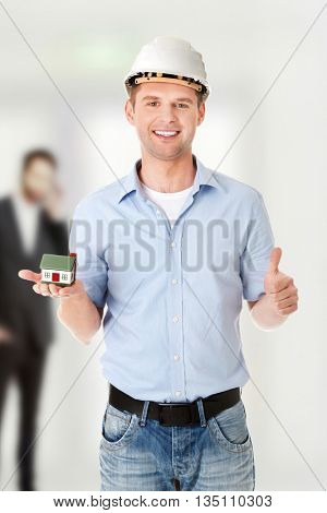 A forewoman holding a model house