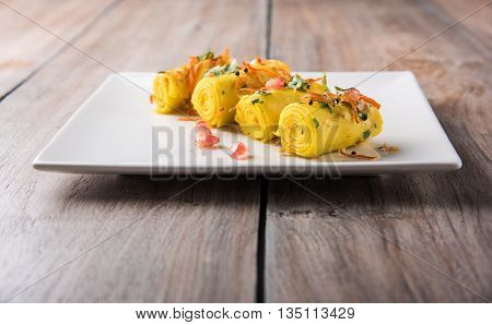 khandvi is a gujarati snack from India which is made with gram flour and curds tempered with sesame seeds and mustard seeds also known as Surali chya Vadya/Stuffed Khandvi, selective focus