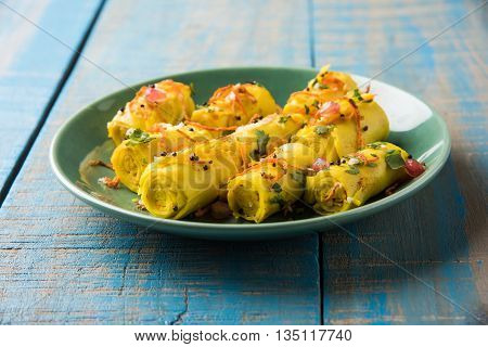 khandvi is a gujarati snack from India which is made with gram flour and curds tempered with sesame seeds and mustard seeds also known as Surali chya Vadya/Stuffed Khandvi, selective focus