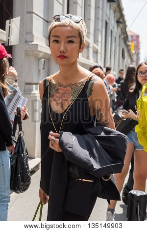 MILAN ITALY - JUNE 18: Fashionable woman poses outside Marni fashion show building for Milan Men's Fashion Week on JUNE 18 2016 in Milan.