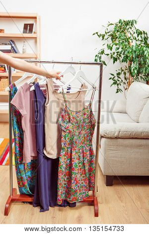 Shopping concept. Woman or lady choosing dresses from wardroom for walk or business purposes. Fashion or vogue concept.