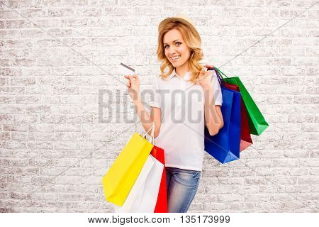 Portrait Of Attractive Shopper Holding Bank Card And Packs With Clothes