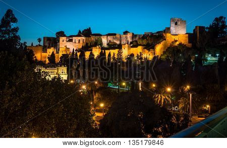 The view of lighted Alkazaba and streets below with street lights in Malaga Spain