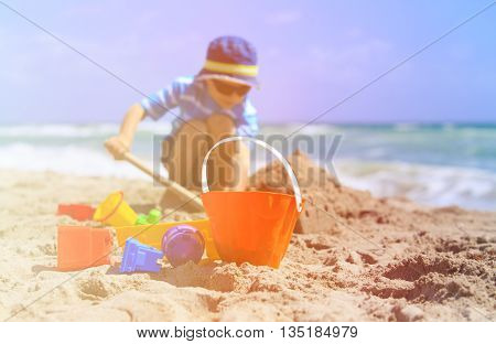 little boy play with sand on summer beach