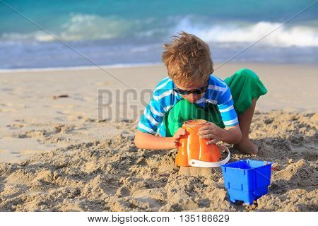 little boy play with sand on summer beach