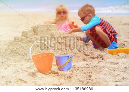kids play with sand on summer beach, family vacation