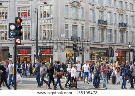 LONDON, UK - OCTOBER 4, 2015: Regent street with lots of walking people crossing the road. Shopping at west end