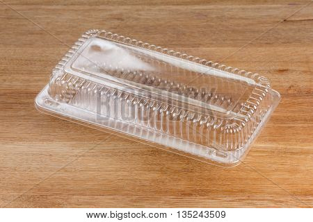 Empty transparent plastic storage box of food package on wooden background